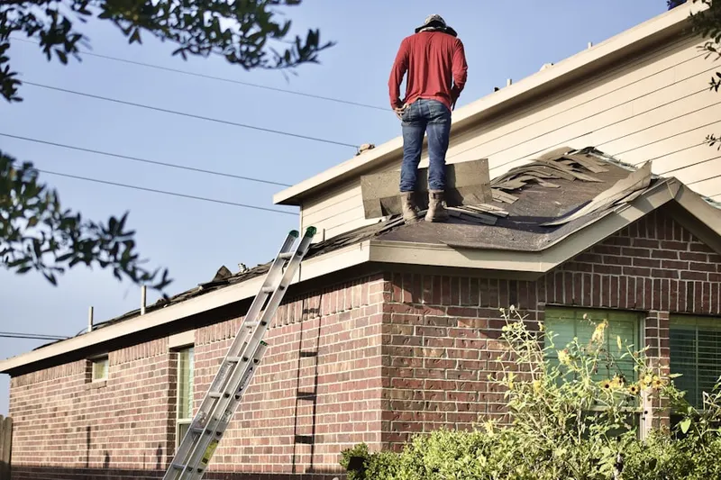 Professional roofer working on a residential roof in Levittown